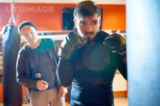 유토이미지 | Waist up portrait of bearded Middle-Eastern fighter hitting punching bag at boxing practice in martial arts club... 