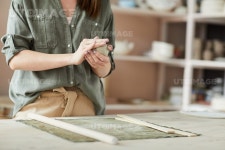 유토이미지 | Close up of unrecognizable female artisan shaping clay while working in pottery studio, copy space
