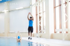 유토이미지 | Full length portrait of African fitness coach working with woman in aqua aerobics class, copy space