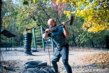 유토이미지 | Muscular bearded man hitting tires with a sledgehammer at outdoor gym