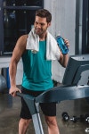 유토이미지 | smiling tired sportsman with towel and sport bottle training on treadmill in gym