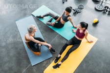 유토이미지 | overhead view of young multicultural sportswomen resting on mats after training at gym
