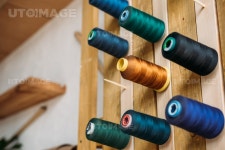 유토이미지 | colored thread coils hanging on wooden wall at sewing workshop