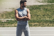 유토이미지 | muscular young man with crossed arms on running track