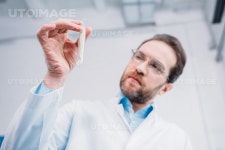 유토이미지 | selective focus of researcher looking at tube in hand