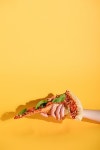 유토이미지 | 상세페이지 | 베이직샵 | 21201340 | partial view of woman holding piece of pizza in hand on yellow background