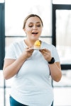 happy overweight woman looking at tasty cupcake in gym | 유토이미지 | 상세페이지 | 베이직샵 | 사진 | 21248696