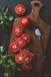 top view of red tomatoes, basil leaves and salt in spoon on cutting board | 유토이미지 | 상세페이지 | 베이직샵 | 사진 | 21279059