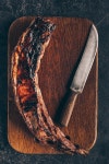 top view of delicious grilled meat with knife on wooden cutting board on black | 유토이미지 | 상세페이지 | 베이직샵 | 사진... 