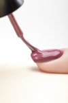 유토이미지 | purple nail polish on fingernail of woman with wet brush on grey background