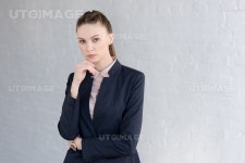 유토이미지 | pensive businesswoman in formal wear posing near white wall