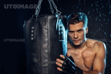 유토이미지 | Boxer holding punching bag and on black 유토이미지 | Boxer holding punching bag and  on black