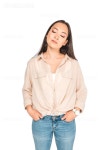 유토이미지 | thoughtful asian woman holding hands in pockets while posing at camera isolated on white