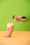 유토이미지 | cropped view of woman holding small hammer and pink piggy bank on green and orange