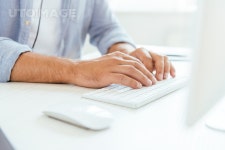 유토이미지 | cropped view of broker typing on computer keyboard near computer mouse