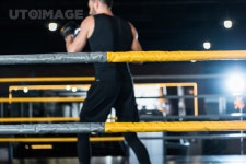 유토이미지 | selective focus of boxing ring with ropes near athletic man exercising in boxing gloves