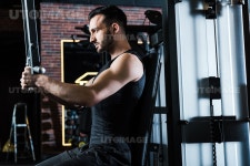 유토이미지 | handsome bearded sportsman exercising on training apparatus in gym