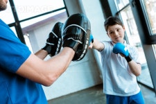 유토이미지 | boy in boxing gloves working out with coach at gym