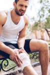유토이미지 | 상세페이지 | 베이직샵 | 21451774 | upset sportsman sitting on bench and touching elastic bandage on injured knee