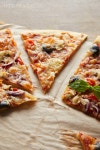 유토이미지 | cut delicious italian pizza with olives on baking paper on wooden table