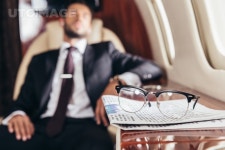 유토이미지 | selective focus of glasses and newspaper on table in private plane