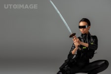 유토이미지 | attractive futuristic african american woman in glasses sitting with sword on grey