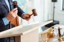유토이미지 | cropped view of auctioneer in suit talking with microphone and holding gavel during auction