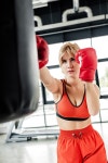유토이미지 | selective focus of young sportswoman in boxing gloves exercising with punching bag