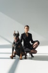elegant woman in black blazer dress near doberman dog on grey background with shadows | 유토이미지 | 상세페이지 | 베이직샵... 
