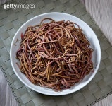 Red pasta noodle in white plate on wooden background decoration with dry flower bush. (949696570) - 게티이미지뱅크