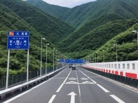 Mountainous Road with Lush Green Hills and Signs | Deep Dream Generator crossing the border from China to Japan | Deep Dream... 
