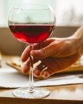 남자는 레드 와인 측면보기와 유리를 잡고있다 | 무료 사진