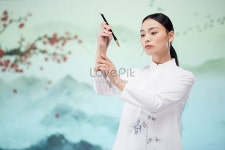  손에 붓으로 서예를 쓰는 중국 스타일의 아름다운 여성