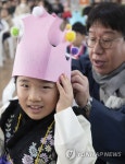 모자 씌워주는 선생님 | 연합뉴스