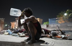 폭염 속 한밤 중 길가에서 물 마시는 인도 남성 | 연합뉴스