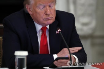 원탁회의 중 휴대전화 들여다보는 트럼프 | 연합뉴스