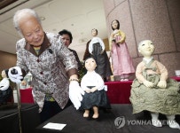 평화의 소녀상 닥종이 인형 살펴보는 안점순 할머니 | 연합뉴스