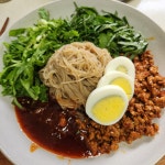 매콤하게 볶은 다진 돼지고기로 고명을 더한 둥지 비빔냉면