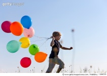 152887078 | 게티이미지코리아 | Boy with colorful balloons in grass Royalty-Free 이미지