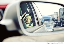 562609321 | 게티이미지코리아 | Reflection in a car wing mirror of a boy sitting in a car Royalty-Free 이미지