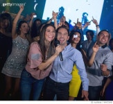 494572940 | 게티이미지코리아 | Happy couple at a karaoke party Royalty-Free 이미지