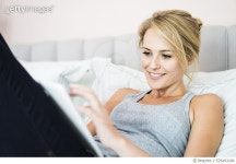 525493280 | 게티이미지코리아 | Happy young woman using tablet PC in bed Royalty-Free 이미지
