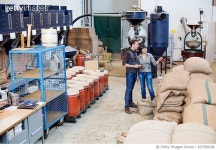 627958168 | 게티이미지코리아 | Modern coffee roaster factory with two people working Royalty-Free 이미지