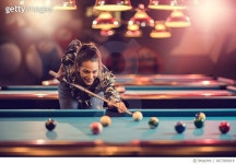 667380818 | 게티이미지코리아 | Smiling woman enjoying while playing billiard in a pub. Royalty-Free 이미지