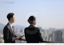 898239086 | 게티이미지코리아 | Business people standing on rooftop terrace Royalty-Free 이미지