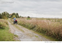 925404412 | 게티이미지코리아 | Mother pushing daughters in bicycle cart Royalty-Free 이미지