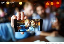 999062048 | 게티이미지코리아 | Smart phone screen displaying a selfie of friends while drinking beer Royalty-Free 이미지