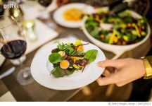 1007325112 | 게티이미지코리아 | Hand holding plate of salad at table during dinner party Royalty-Free 이미지