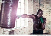 983494156 | 게티이미지코리아 | Black boxer punching the heavy bag in the gym Royalty-Free 이미지