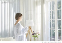 PFLRF19001516 | 게티이미지코리아 | 커피잔을 들고 창밖을 바라보며 서 있는 젊은여자 Royalty-Free 이미지